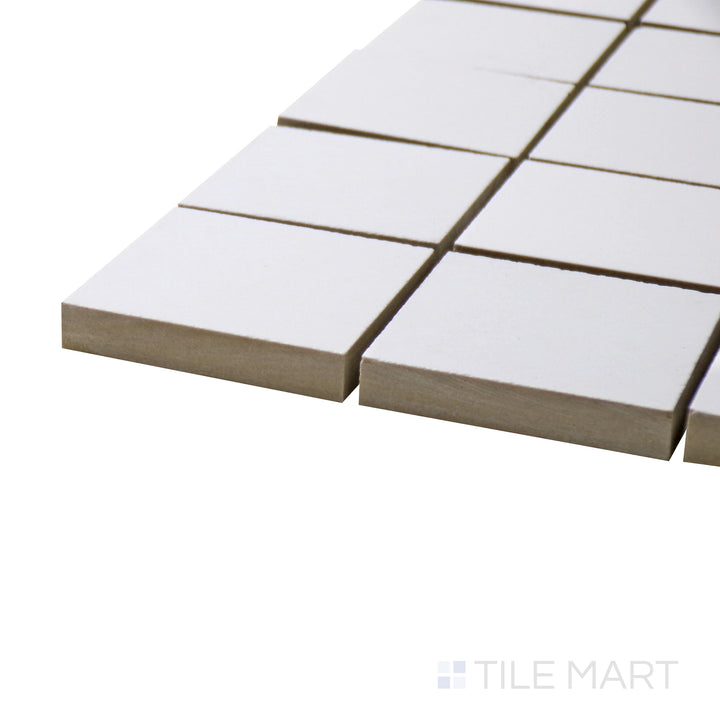 Captured from a corner angle, the Pearl Super White 2" square polished porcelain mosaic tile showcases its reflective surface and brilliant white hue, perfect for backsplashes and accent walls.