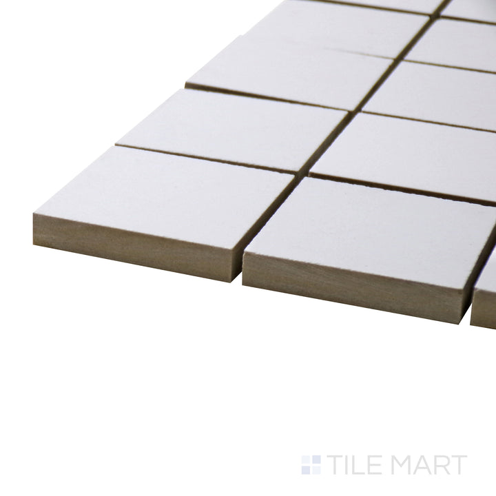 A corner perspective of the Pearl Super White 2" square matte porcelain mosaic tile emphasizes its smooth texture and versatile white tone, offering a subtle yet refined aesthetic.