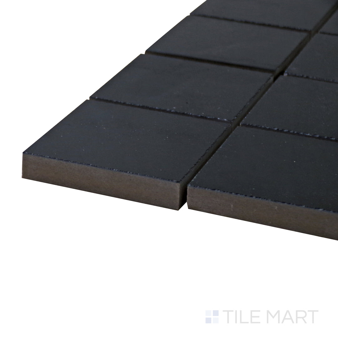 Captured from a corner angle, the Pearl Super Black 2" square polished porcelain mosaic tile showcases its rich black shade and glossy surface, making it a stunning accent choice.