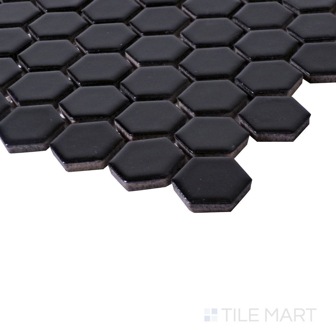 Angled close-up capturing the deep black finish of Porcelain Glazed Black 1" Hexagon Matte mosaic.