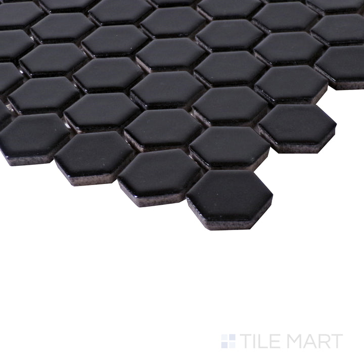 Angled close-up capturing the deep black finish of Porcelain Glazed Black 1" Hexagon Matte mosaic.
