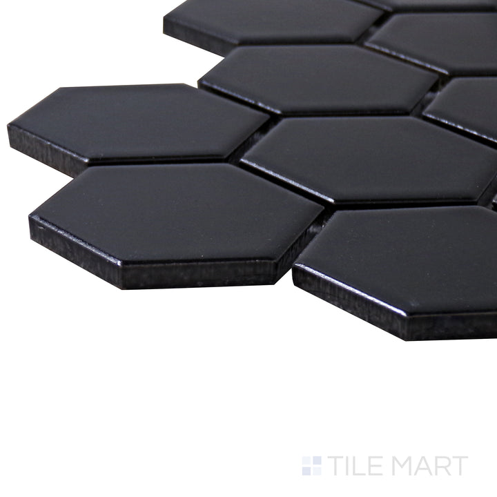 A corner shot of the Porcelain Glazed Mosaics Black 2" hexagon matte tile highlights its geometric design and deep black hue, adding a dramatic accent to any space.