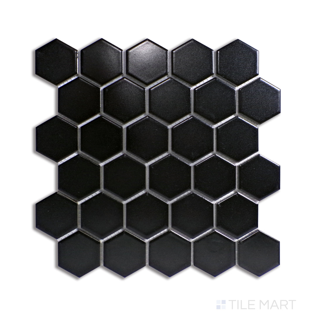 A bold black 2-inch hexagonal matte mosaic tile, offering a larger geometric arrangement, displayed from above to emphasize its deep color and sharp edges.