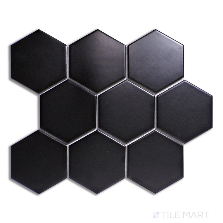 A dramatic black 4-inch hexagonal matte porcelain tile, featuring a bold, large-scale honeycomb structure, captured from a top-down view for clarity.