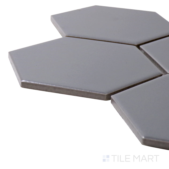 Captured from a corner angle, the Porcelain Glazed Mosaics Gray 4" hexagon matte tile showcases its neutral gray hue and modern matte surface, making it a stylish and adaptable choice.
