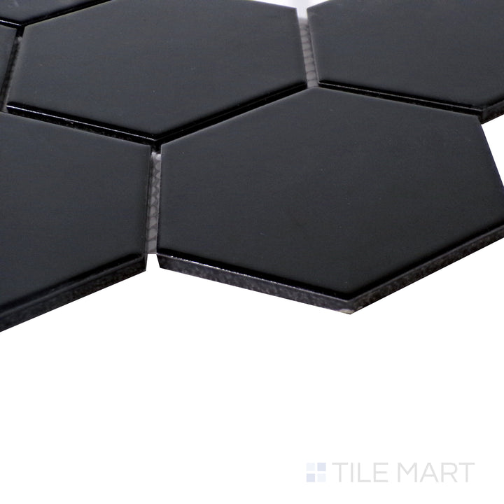 Reflective angle shot showcasing the deep black finish of Porcelain Glazed Black 4" Hexagon Glossy mosaic.