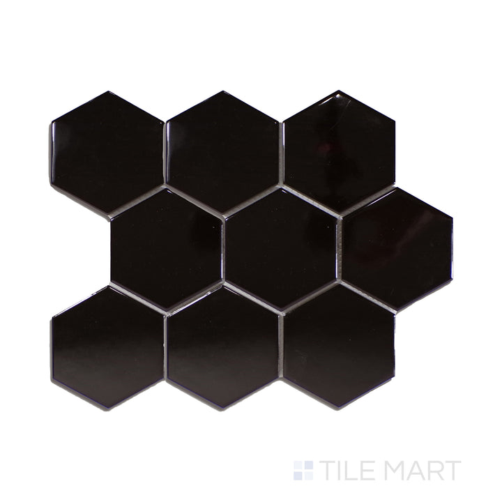 A striking black 4-inch hexagonal glossy porcelain mosaic, offering a reflective surface, displayed from an overhead perspective to accentuate its sheen.
