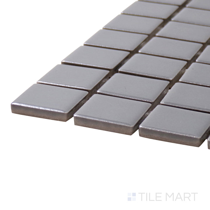Captured from a corner angle, the Porcelain Glazed Mosaics Gray 1" Square Matte tile showcases its smooth matte finish and neutral gray hue, ideal for modern interiors.