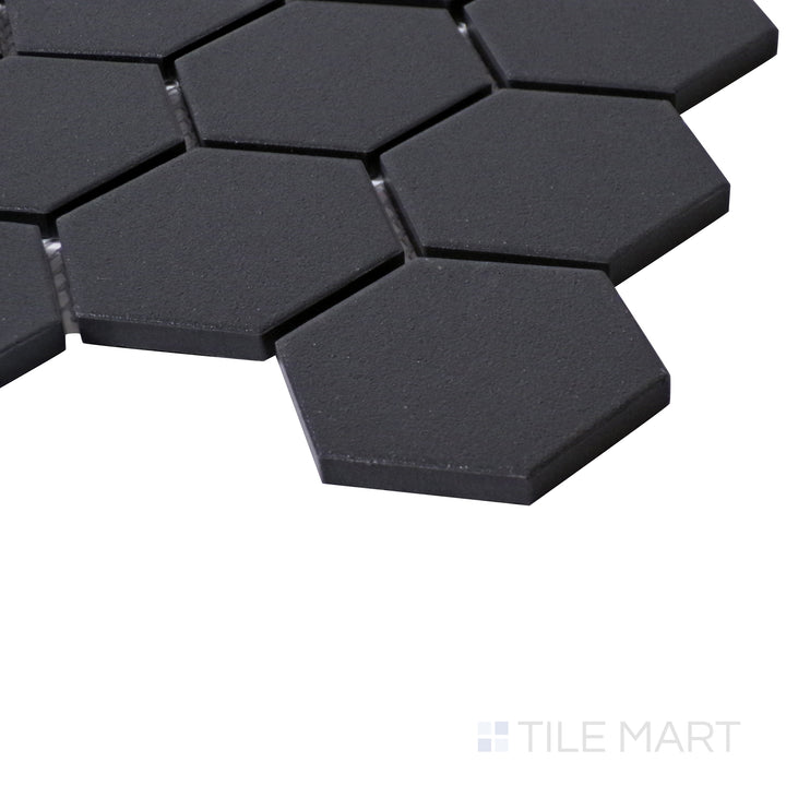 A sharp angle shot emphasizing the deep black tones and structured hexagonal design of Solids Black 2" Hexagon Matte Porcelain Mosaic.