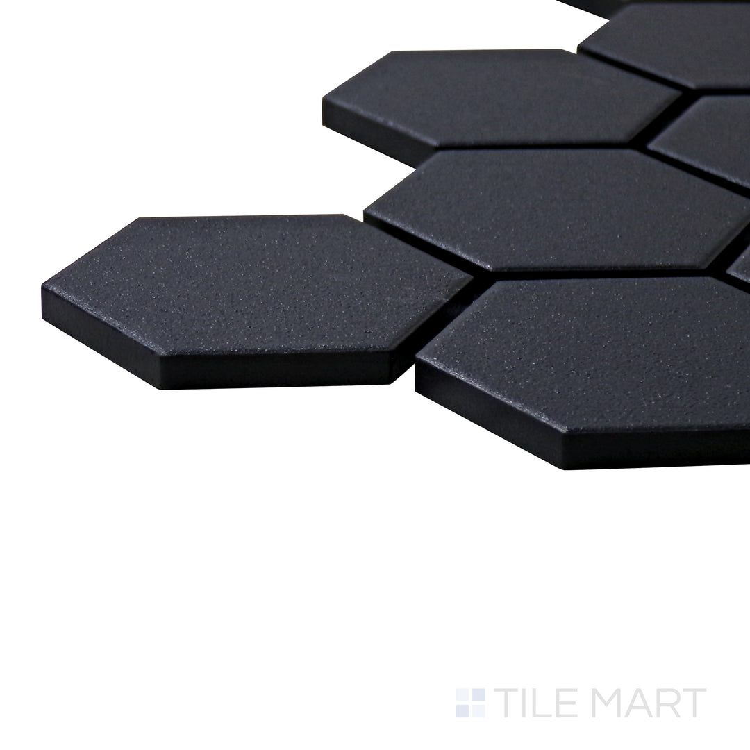 A corner shot of the Solids Black 2" Hexagon Matte Porcelain Mosaic tile highlights its rich black tone and geometric hexagonal shape for a contemporary and bold look.
