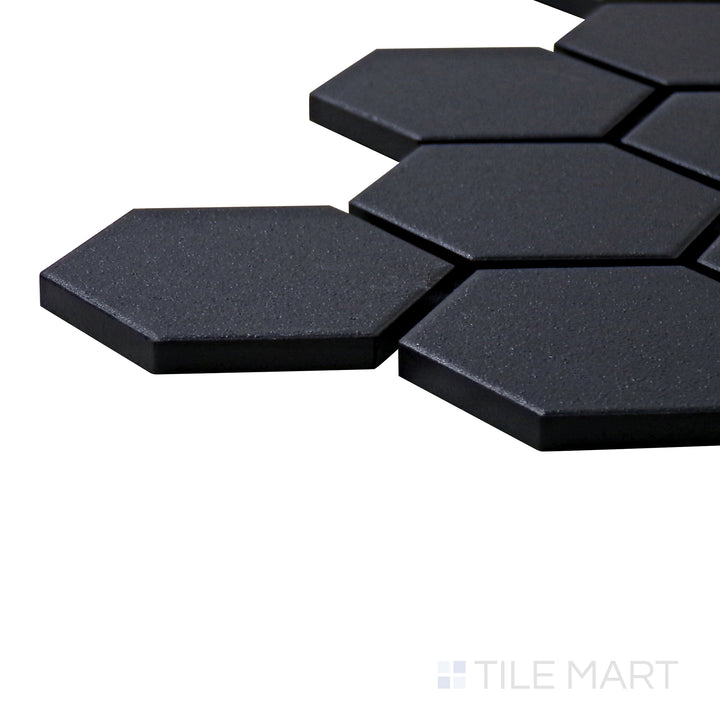 A corner shot of the Solids Black 2" Hexagon Matte Porcelain Mosaic tile highlights its rich black tone and geometric hexagonal shape for a contemporary and bold look.