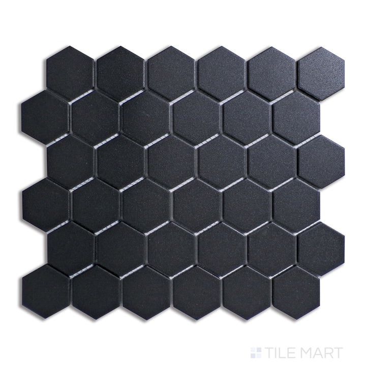 Top-down view of black 2-inch hexagon matte porcelain mosaic tiles, creating a bold geometric pattern perfect for modern and industrial spaces.