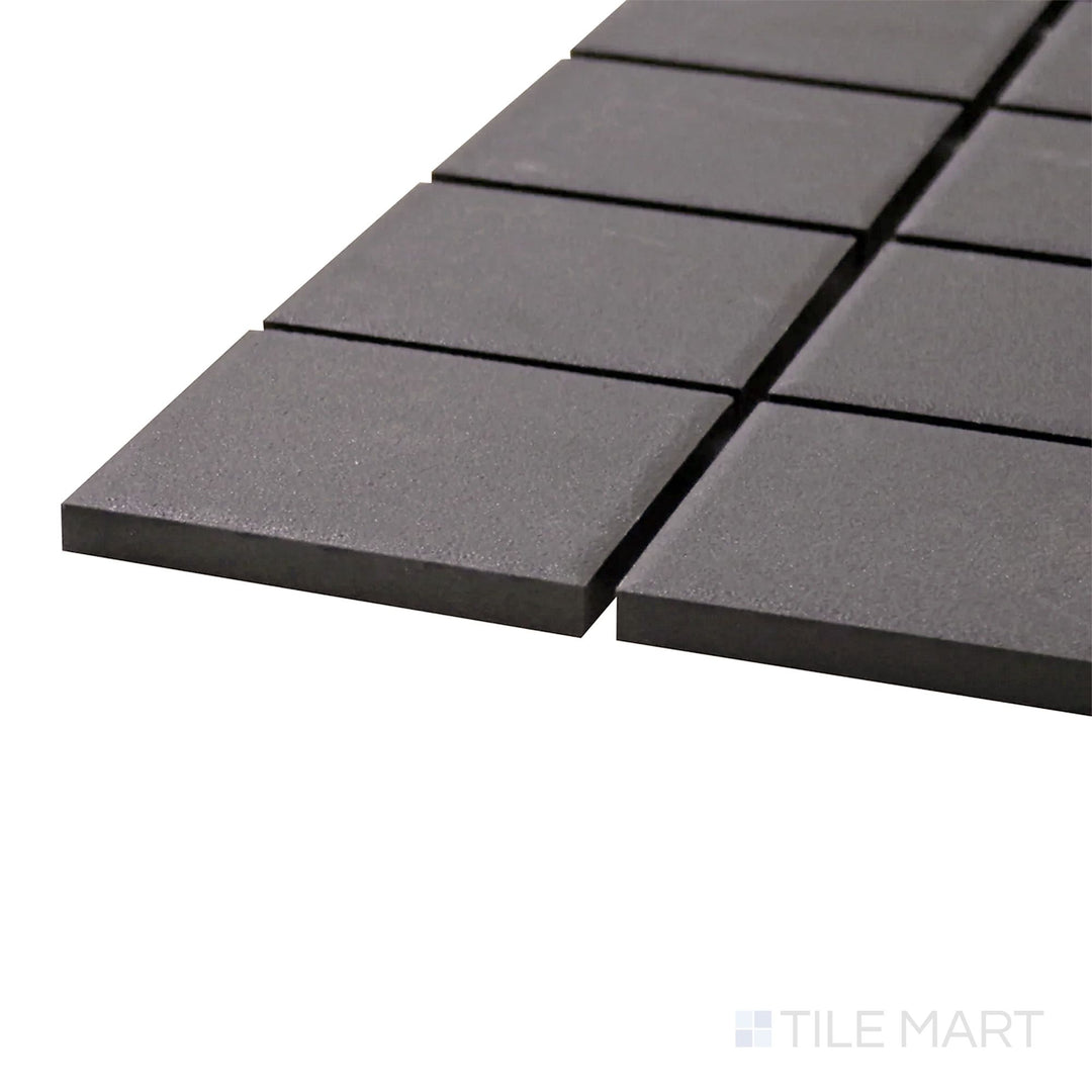 A corner shot of the Solids Black 2" Square Matte Porcelain Mosaic tile showcases its classic square shape and deep black matte finish for a versatile and sleek design.