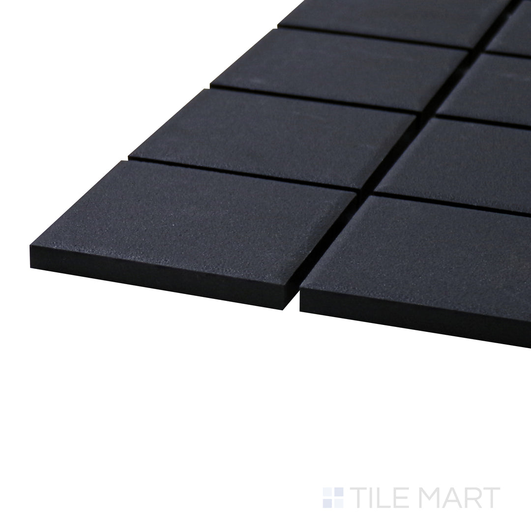 A corner shot of the Solids Black 2" Square Matte Porcelain Mosaic tile showcases its classic square shape and deep black matte finish for a versatile and sleek design.
