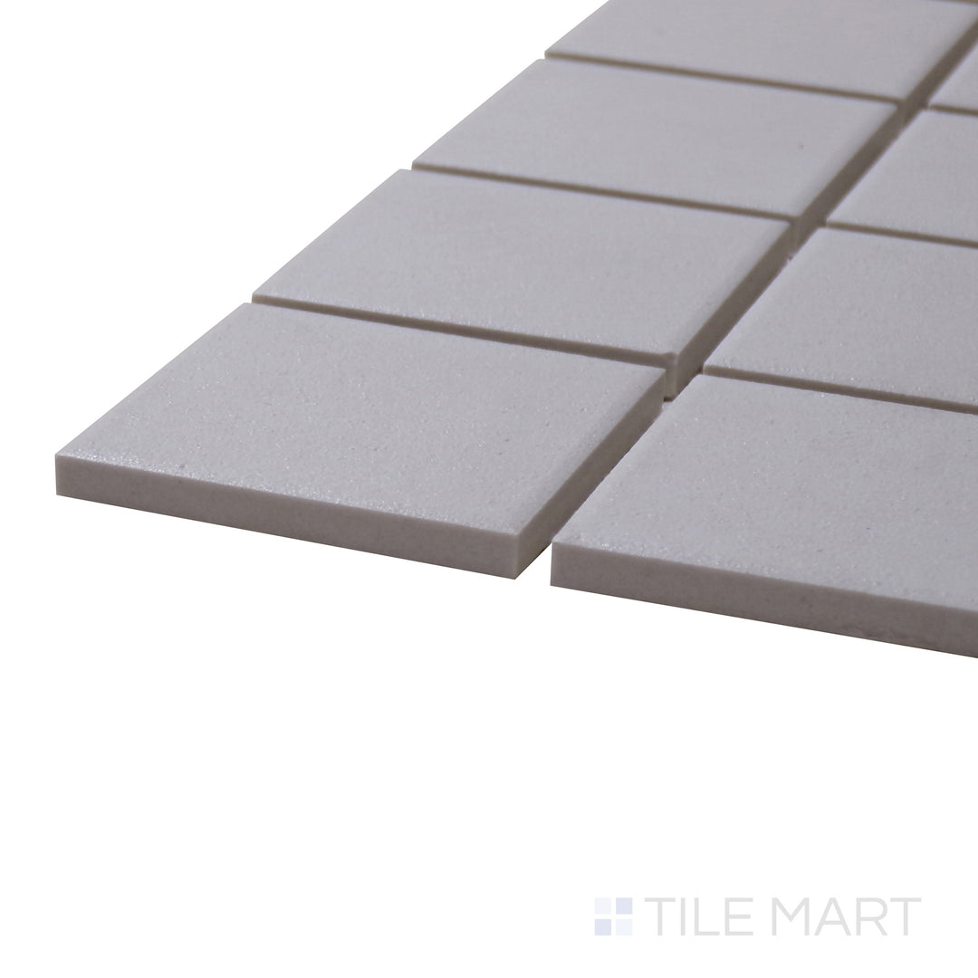 A corner perspective of the Solids White 2" Square Matte Porcelain Mosaic tile highlights its bright white shade and classic square format, ideal for creating a fresh and timeless space.