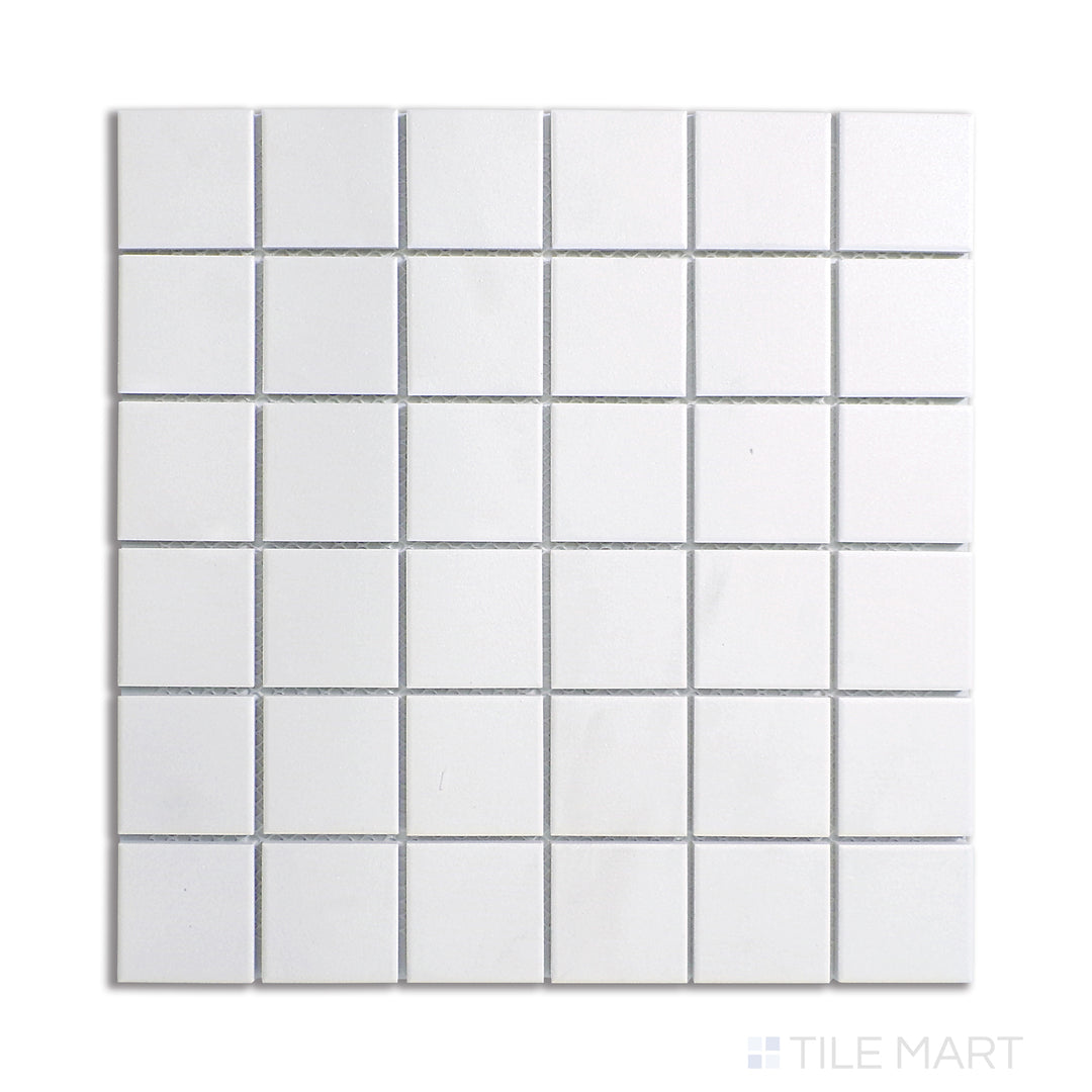 Top-down view of white 2-inch square matte porcelain mosaic tiles, providing a bright and uniform pattern that adds a timeless touch to any space.