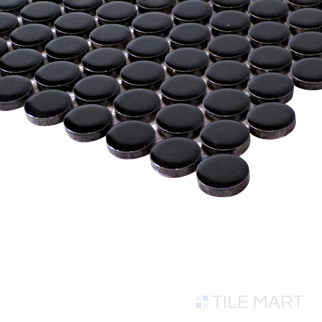 Angled shot highlights the deep black hues and high-gloss finish of Pure Black Penny Round Glossy Porcelain Mosaic, reflecting light beautifully.