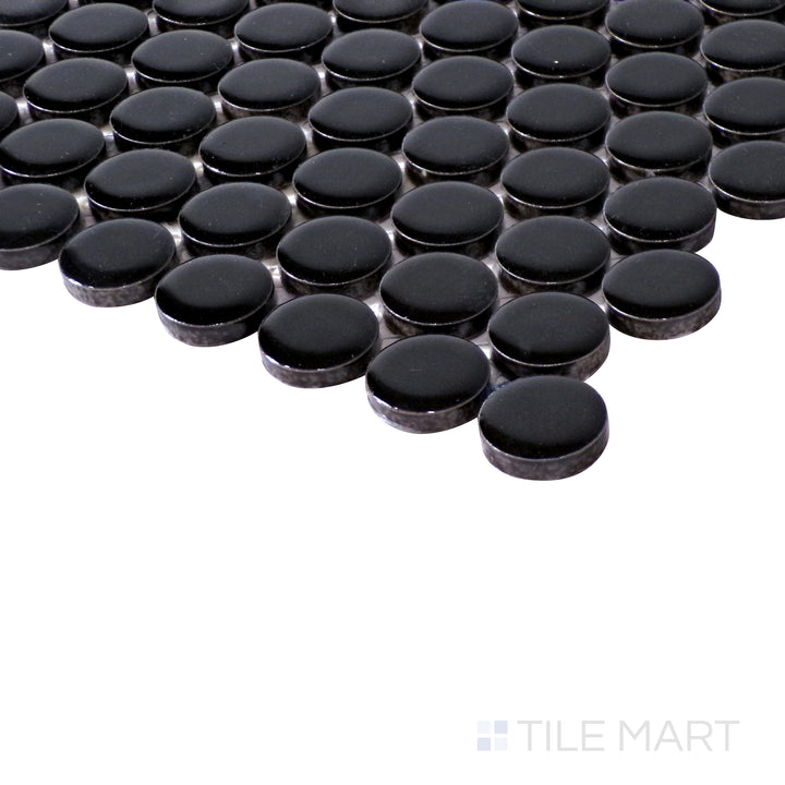 Angled shot highlights the deep black hues and high-gloss finish of Pure Black Penny Round Glossy Porcelain Mosaic, reflecting light beautifully.