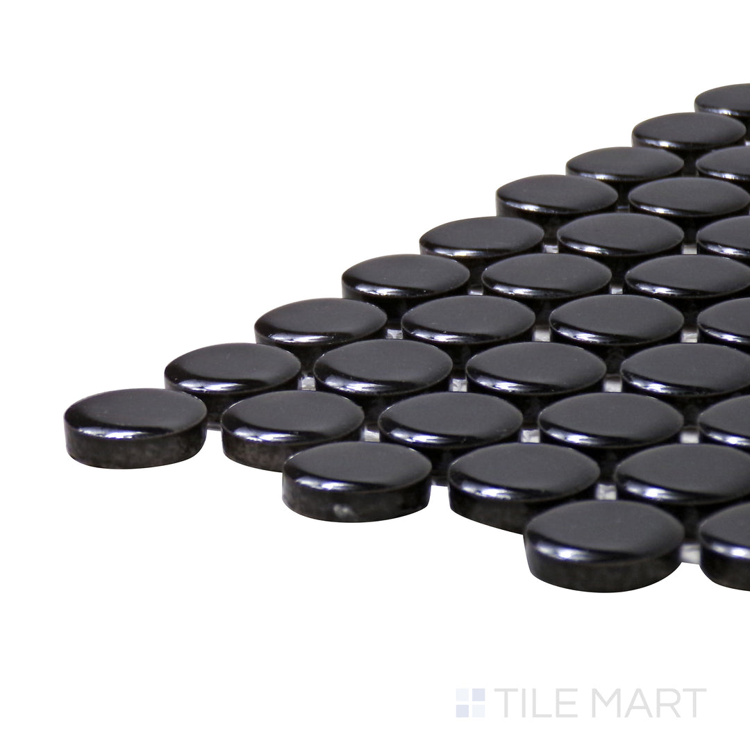 A corner shot of the Pure Black Penny Round Glossy Porcelain Mosaic highlights its deep black hue and reflective glossy finish, adding bold contrast to any space.