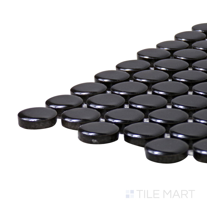 A corner shot of the Pure Black Penny Round Glossy Porcelain Mosaic highlights its deep black hue and reflective glossy finish, adding bold contrast to any space.