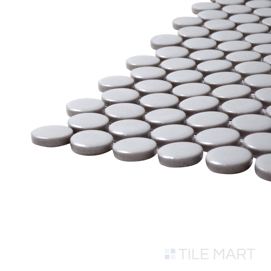 Captured from a corner angle, the Pure Grey Penny Round Matte Porcelain Mosaic offers a soft neutral grey with a subtle matte surface, blending seamlessly into any décor.