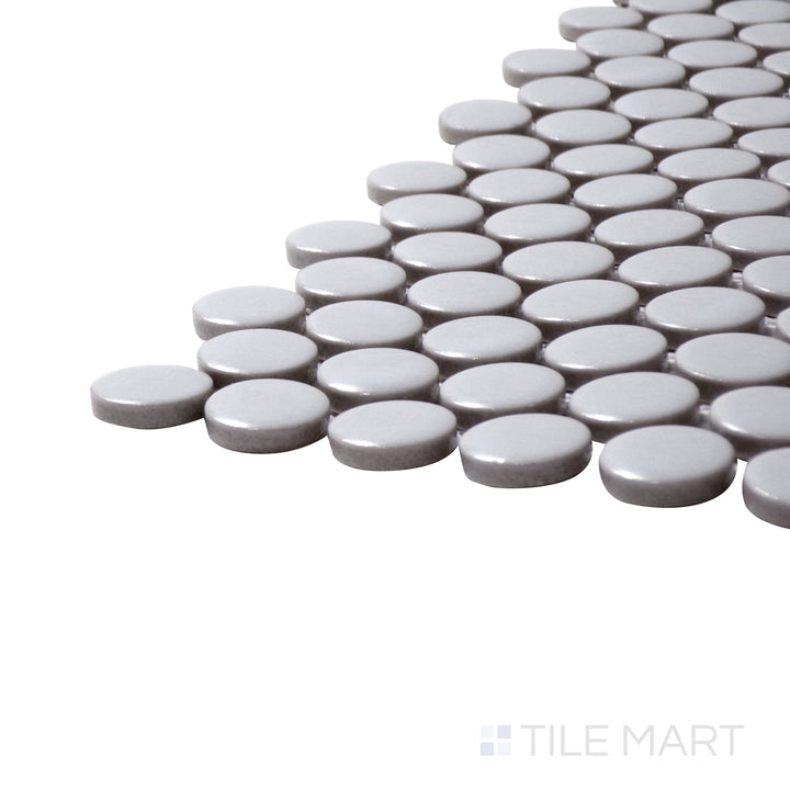 Captured from a corner angle, the Pure Grey Penny Round Matte Porcelain Mosaic offers a soft neutral grey with a subtle matte surface, blending seamlessly into any décor.