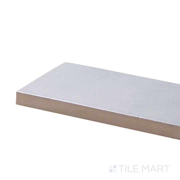 Captured from a corner angle, the Safi Grey 2X6 Glossy Ceramic tile presents a soft grey tone with a reflective glossy surface, creating a sophisticated, neutral aesthetic.