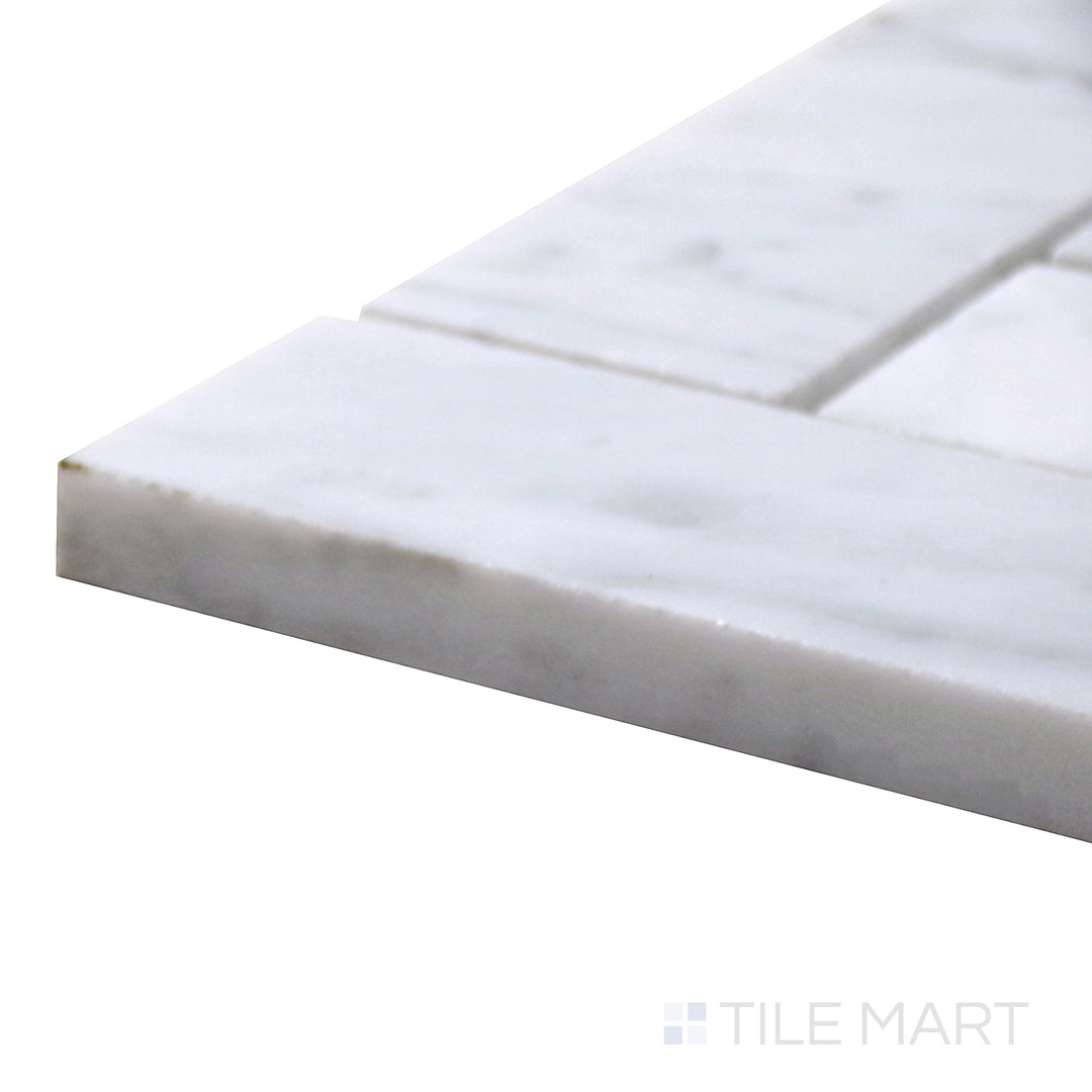 Angled view of Sto-Re Carrara Herringbone Polished Marble Mosaic, featuring classic white marble with elegant gray veining in a herringbone layout.