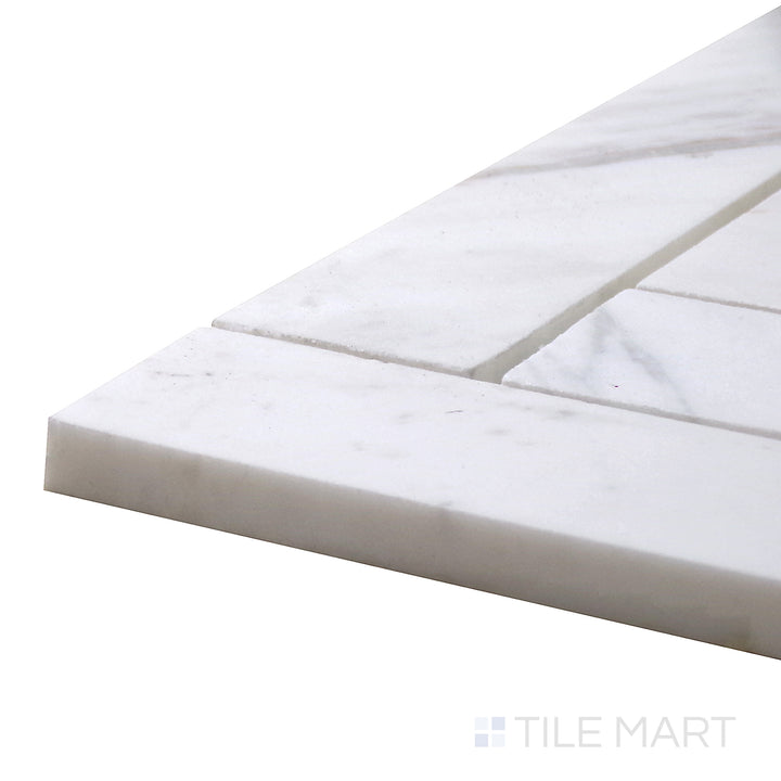 Detailed corner shot of Sto-Re Volakas Herringbone Polished Marble Mosaic, showcasing its soft gray veining in a sleek, polished herringbone design.