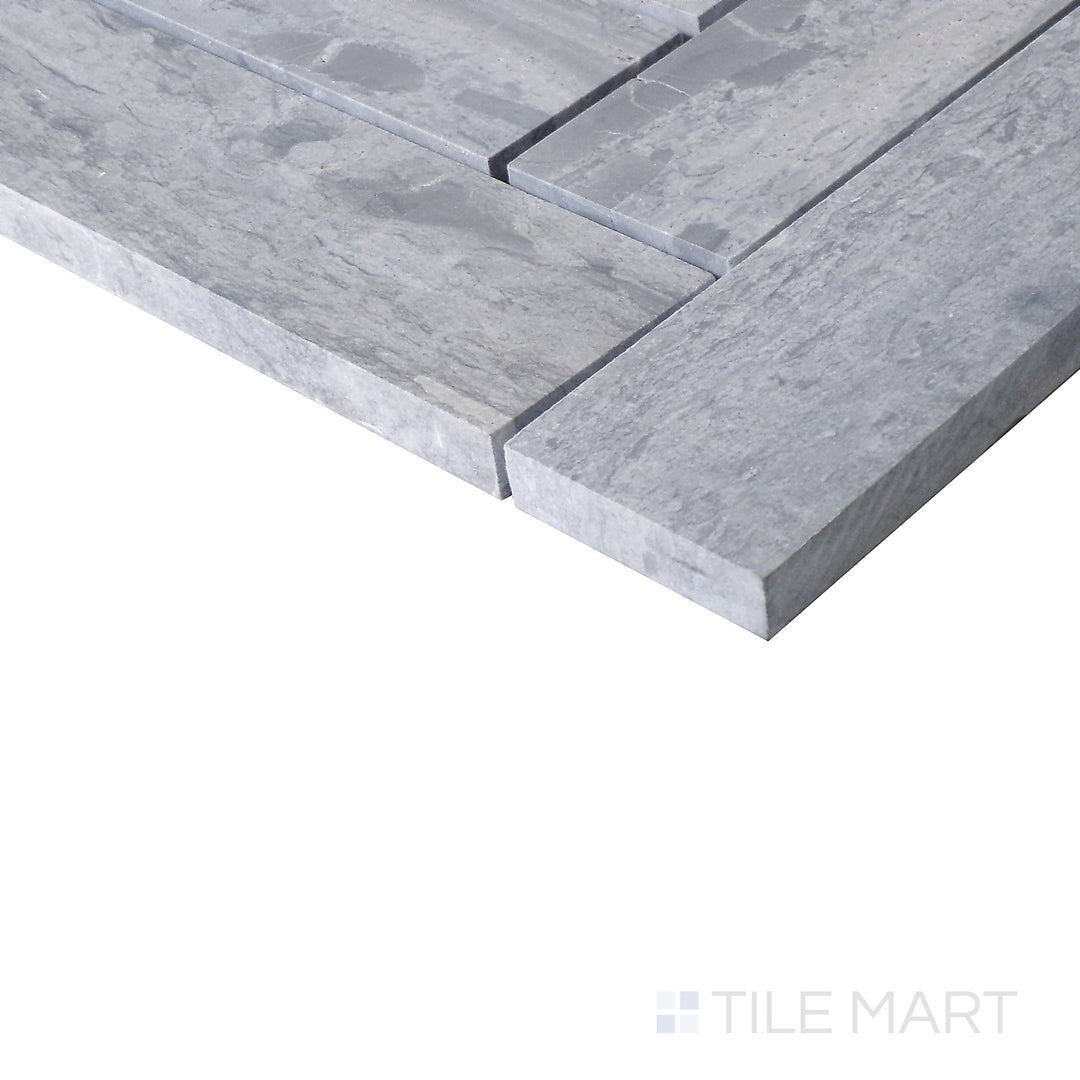 Slanted view of Sto-Re Wooden Blue Herringbone polished marble mosaic, capturing its soft blue-gray hues, polished surface, and dynamic herringbone pattern.  