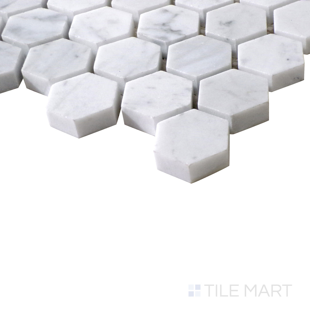 Angled shot of Sto-Re Carrara 1-1/8" Hexagon polished marble mosaic, featuring a refined white marble base with subtle gray veining in a small hexagonal layout.  