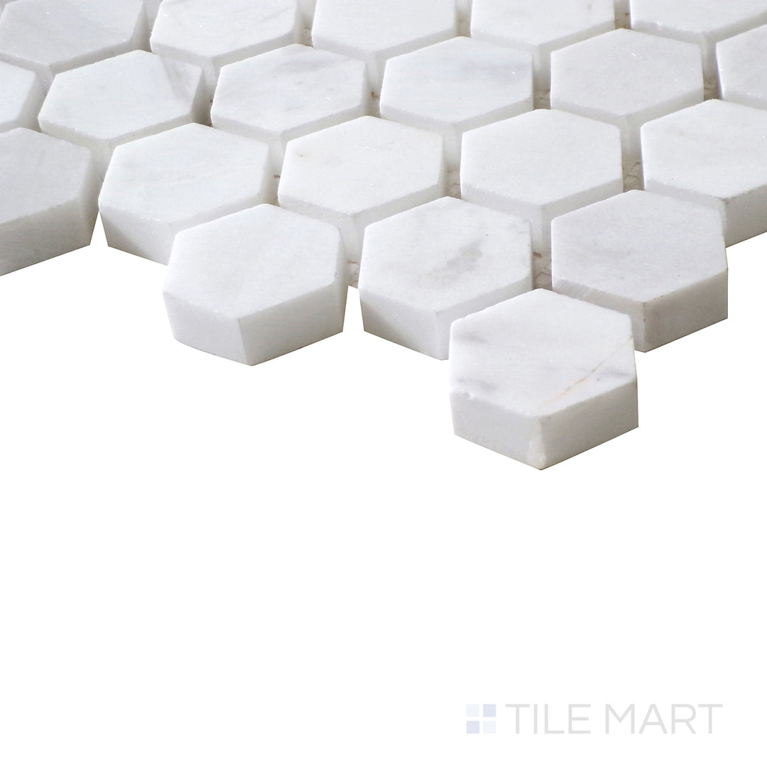 Angled shot of Sto-Re Volakas 1-1/8" Hexagon polished marble mosaic, emphasizing its soft veining, high-gloss finish, and well-defined hexagonal pattern.  
