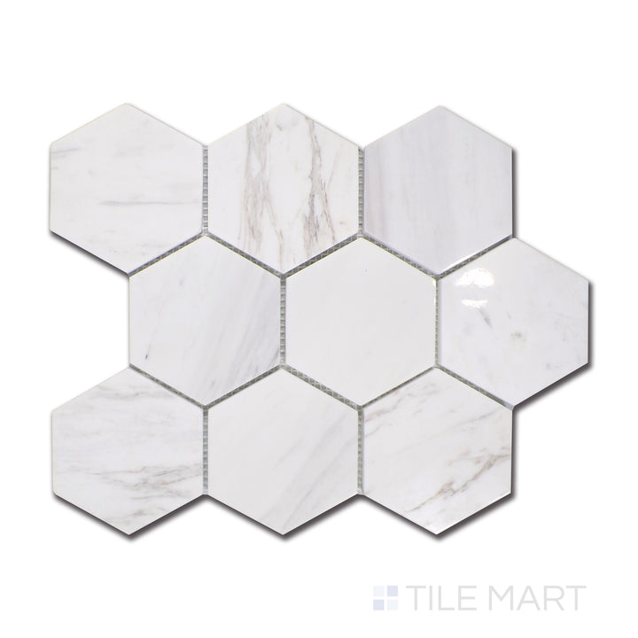 An overhead look at Volakas marble arranged in a bold 4-inch hexagon structure, harmonizing classic white surfaces with fluid, smoky gray veining, enhanced by a polished touch.