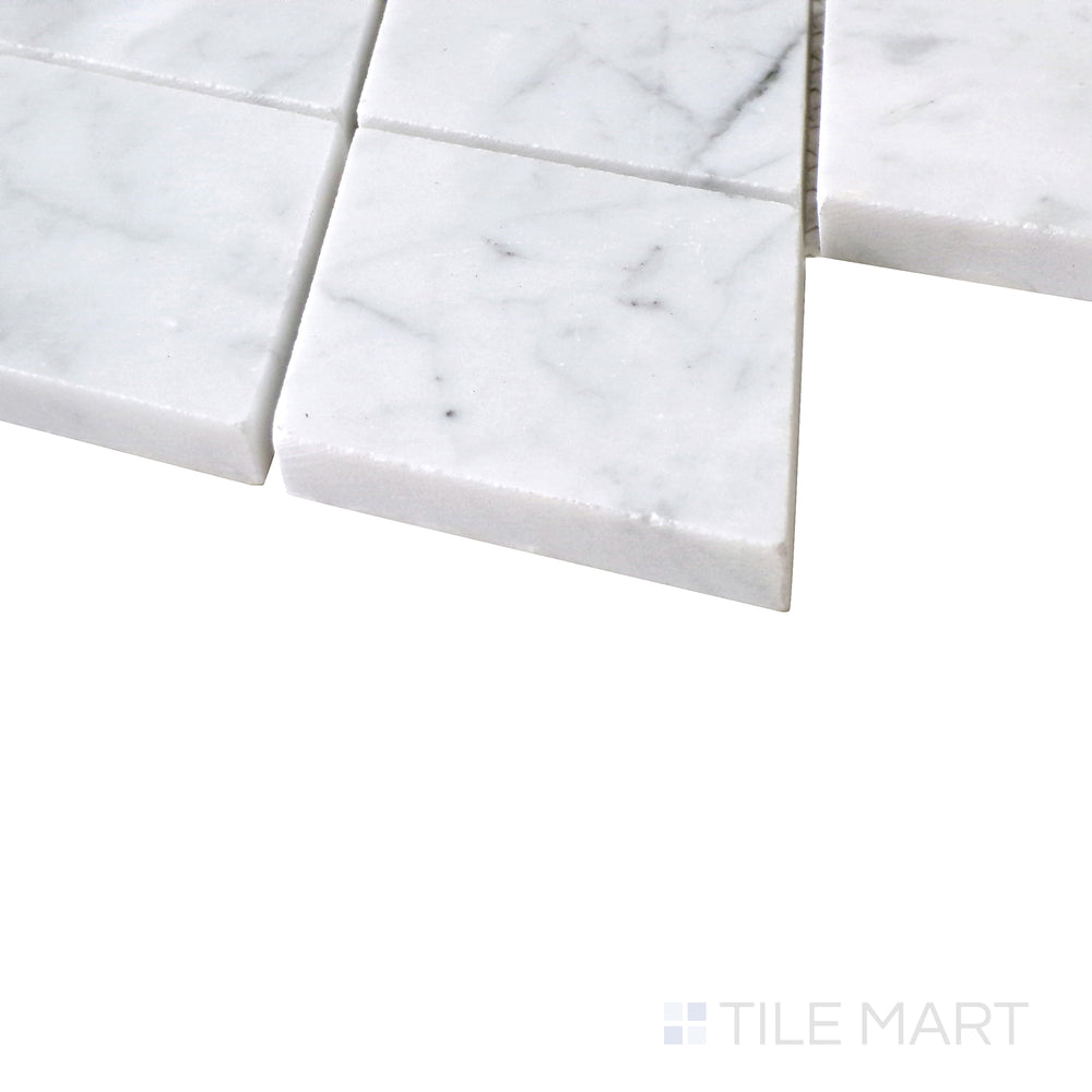 Diagonal angle of Sto-Re Carrara Rhomboid polished marble mosaic, showcasing its classic white marble, subtle gray veining, and dynamic rhomboid pattern.  