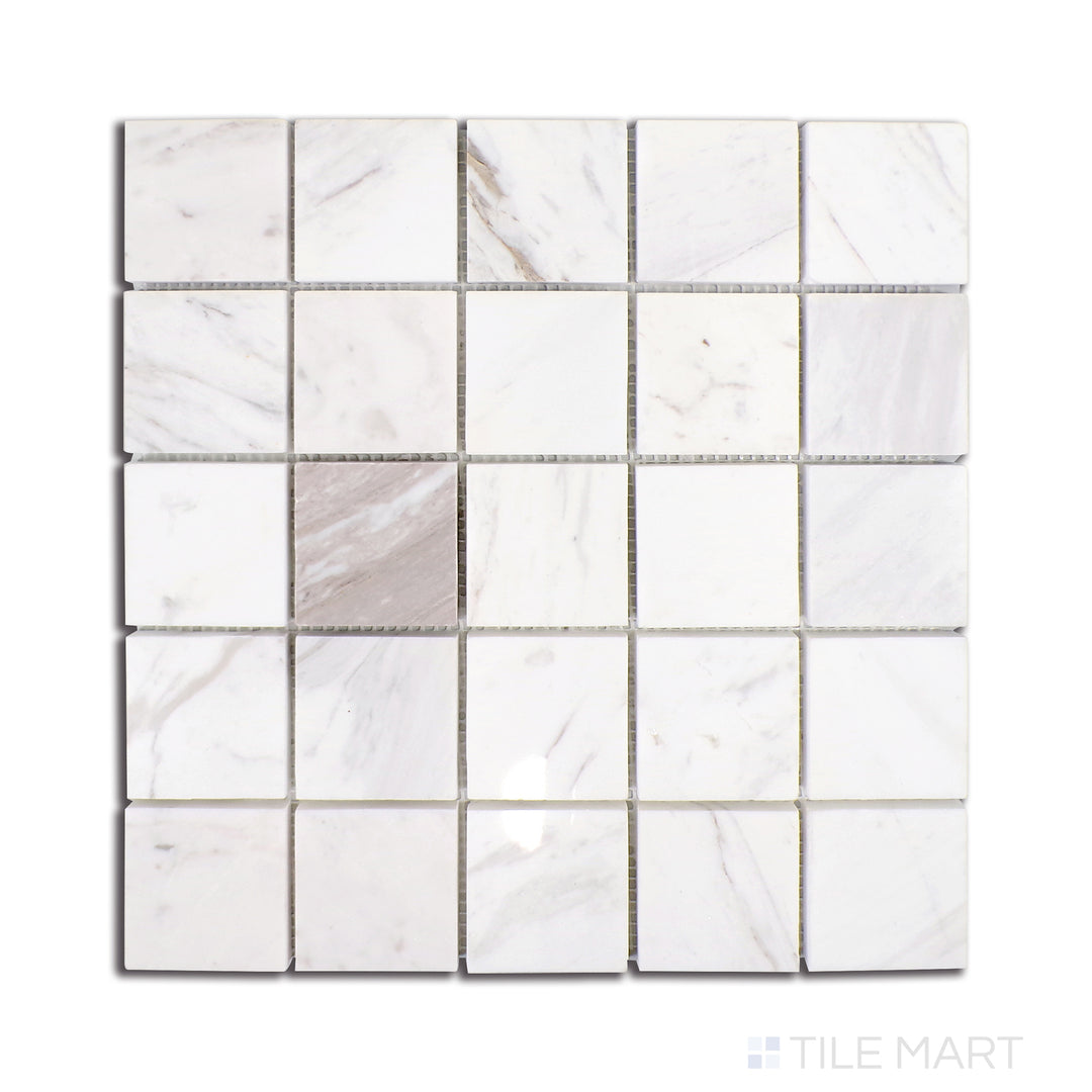 Soft, cloud-like veins drift across the Volakas marble tiles, which are meticulously arranged in a 2.25-inch square pattern and polished for a luxurious finish, as seen from above.