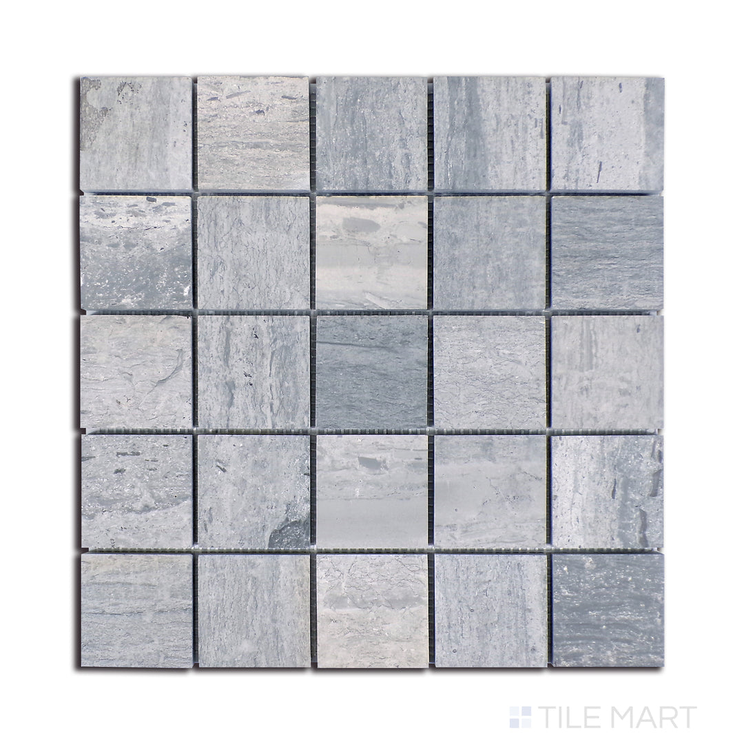 A top-down display of Wooden Blue marble, arranged in 2.25-inch square segments, showcases deep blue-gray tones with subtle, wood-like striations.