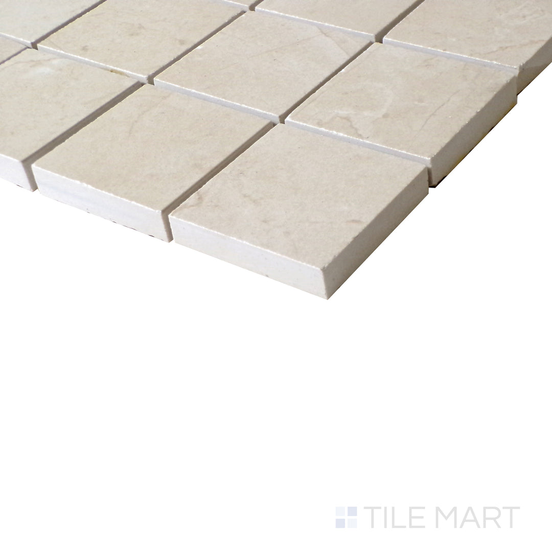 Slanted perspective of Tele Di Marmo Reloaded Marfil 2" Square matte porcelain mosaic, emphasizing its warm beige tones, soft veining, and geometric square arrangement.  