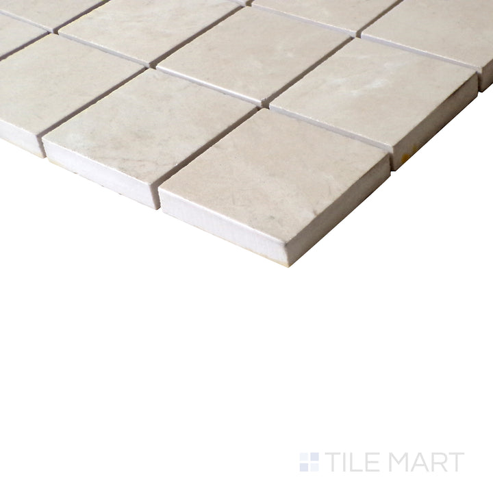 Angled shot of Tele Di Marmo Reloaded Marfil 2" Square polished porcelain mosaic, featuring its warm beige hues, soft veining, and elegant polished surface.  