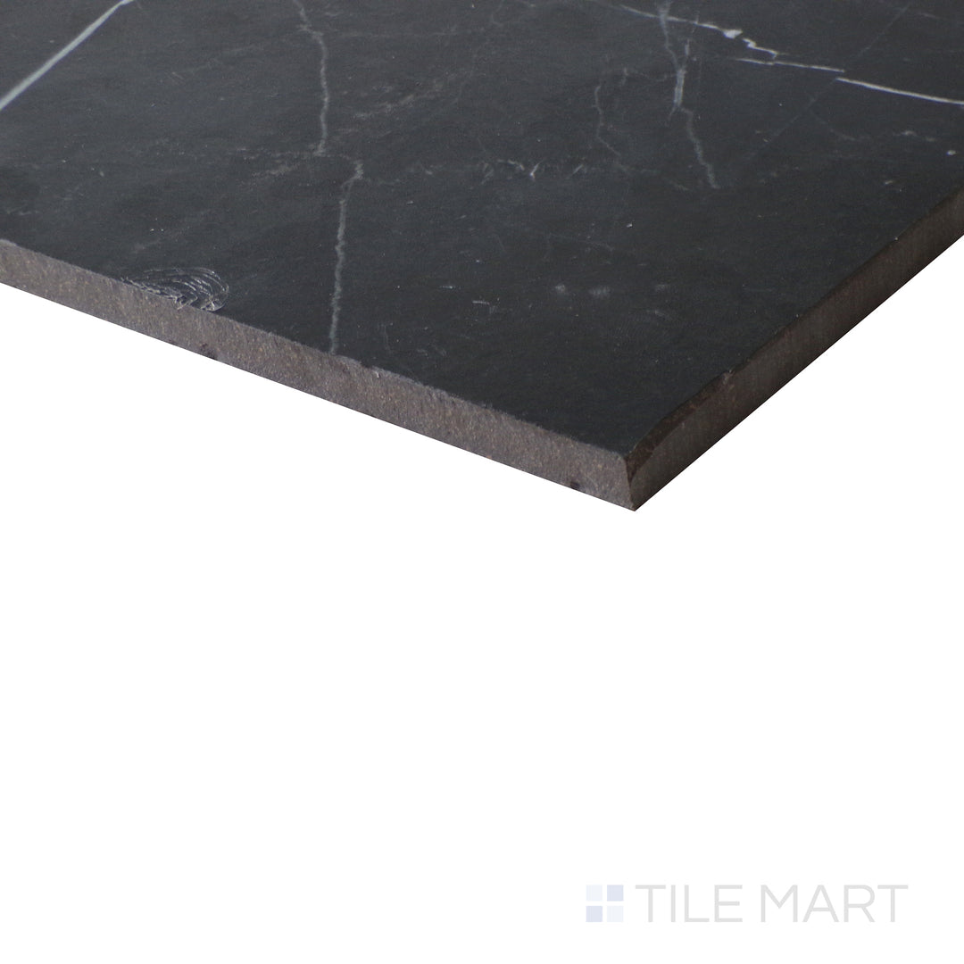 Angled shot of Tele Di Marmo Revolution Calacatta Black 24x48 matte porcelain tile, featuring deep black veins contrasting against a white base with a smooth matte finish.  
