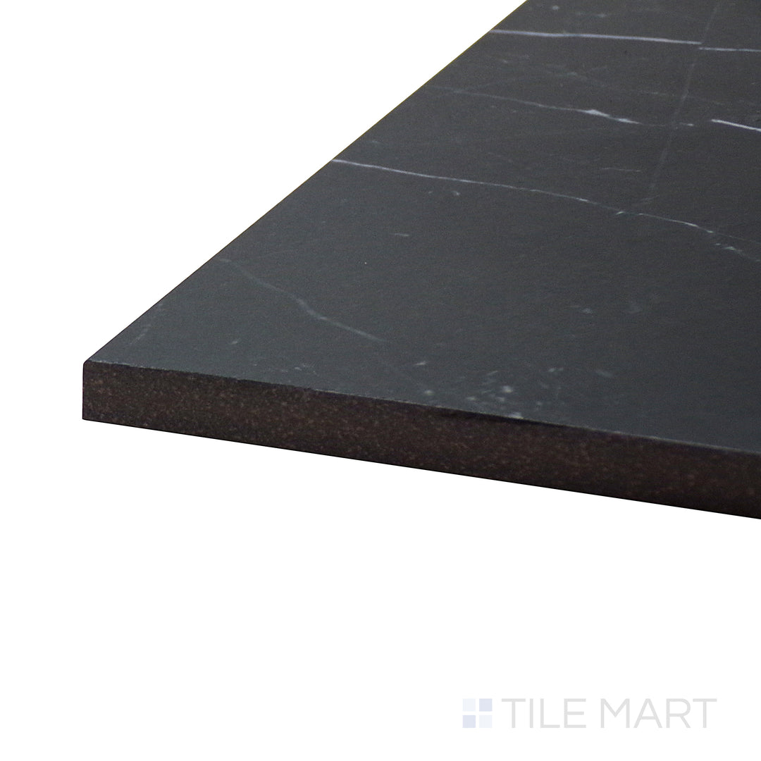 Angled view of Tele Di Marmo Revolution Calacatta Black 24X48 Matte Porcelain Tile, showcasing its dramatic black marble-inspired surface with striking white veining.