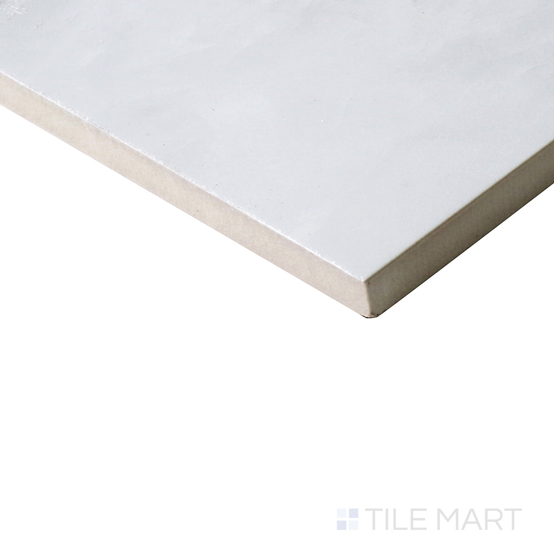 Angled shot of Tele Di Marmo Revolution Thassos 24x48 polished porcelain tile, showcasing its pristine white surface, luxurious sheen, and expansive format.  