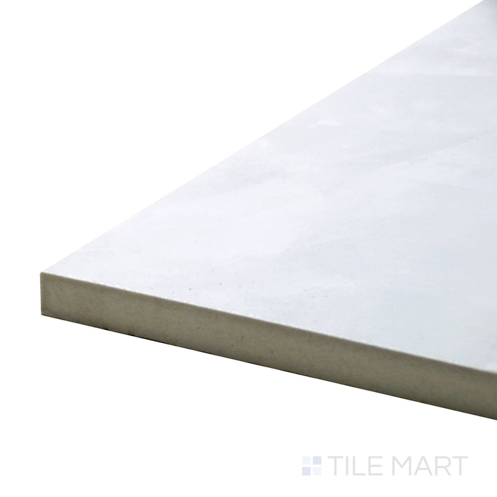 Angled close-up of Tele Di Marmo Revolution Thassos 24X48 Polished Porcelain Tile, featuring its bright white marble surface with a sleek polished finish.