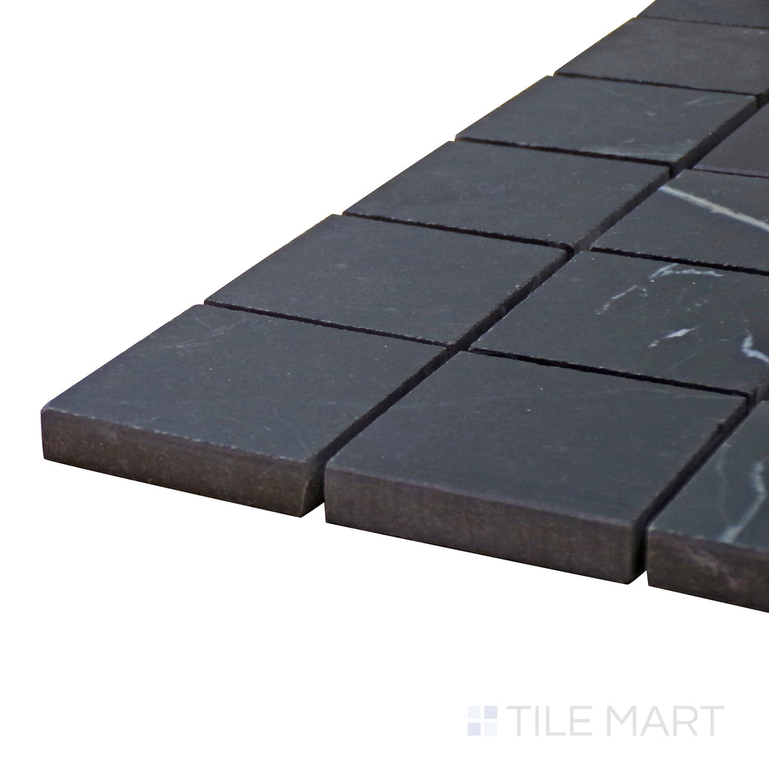 Side perspective of Tele Di Marmo Revolution Calacatta Black 2" Square Matte Porcelain Mosaic, capturing its dramatic black-and-white marble veining in a structured square format.