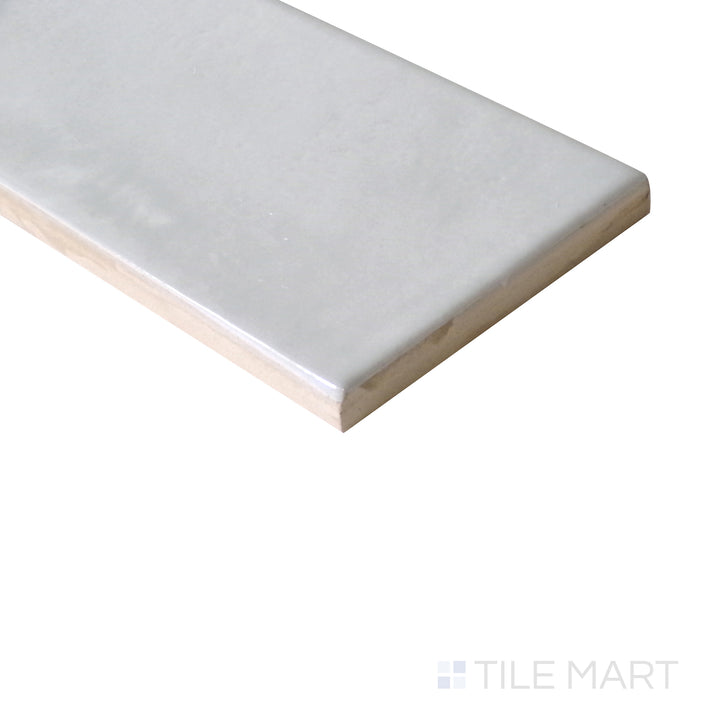 Diagonal view of Village Silver Mist 2.5x8 glossy ceramic tile, showcasing its soft silver-gray hue, smooth glossy surface, and elongated design.  