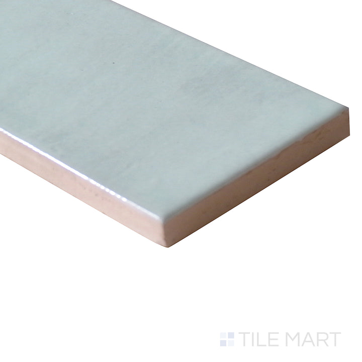 Diagonal view of Village Cloud 2.5x8 glossy ceramic tile, featuring a soft gray-blue tone, smooth polished finish, and contemporary rectangular layout.  