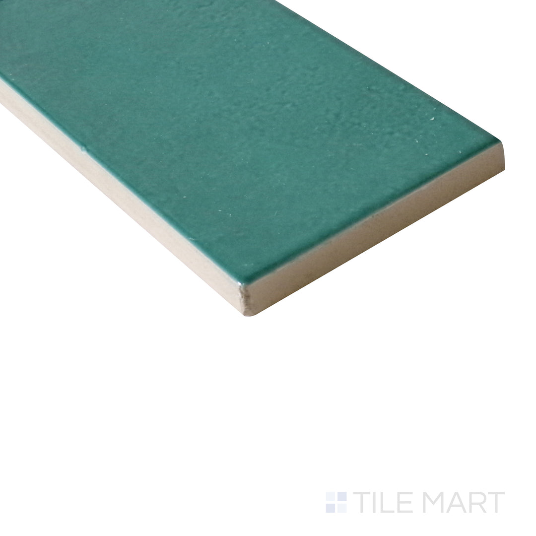 Slanted angle of Village Emerald Green 2.5x8 glossy ceramic tile, capturing its rich green tones, high-gloss finish, and refined rectangular format.  