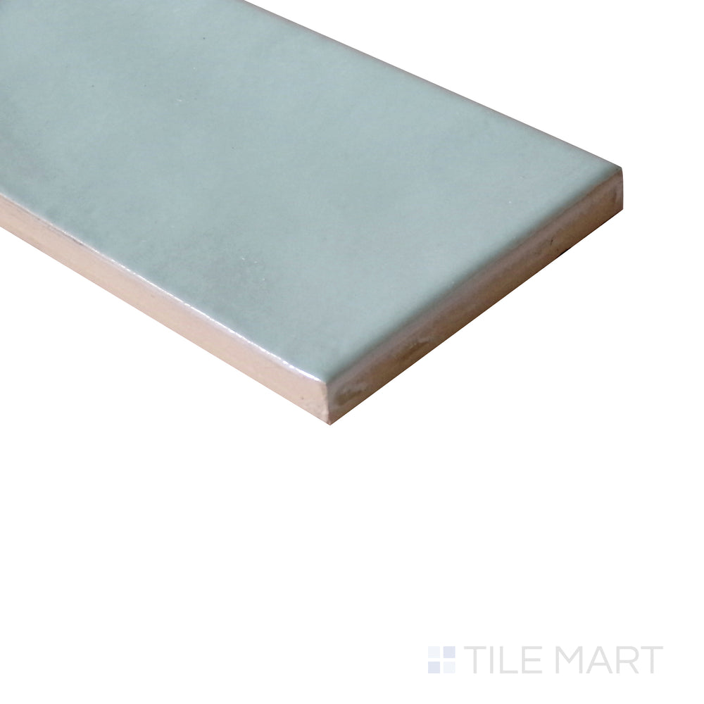 Angled shot of Village Mint 2.5x8 glossy ceramic tile, showcasing its pastel mint green color, glossy texture, and sleek rectangular design.  
