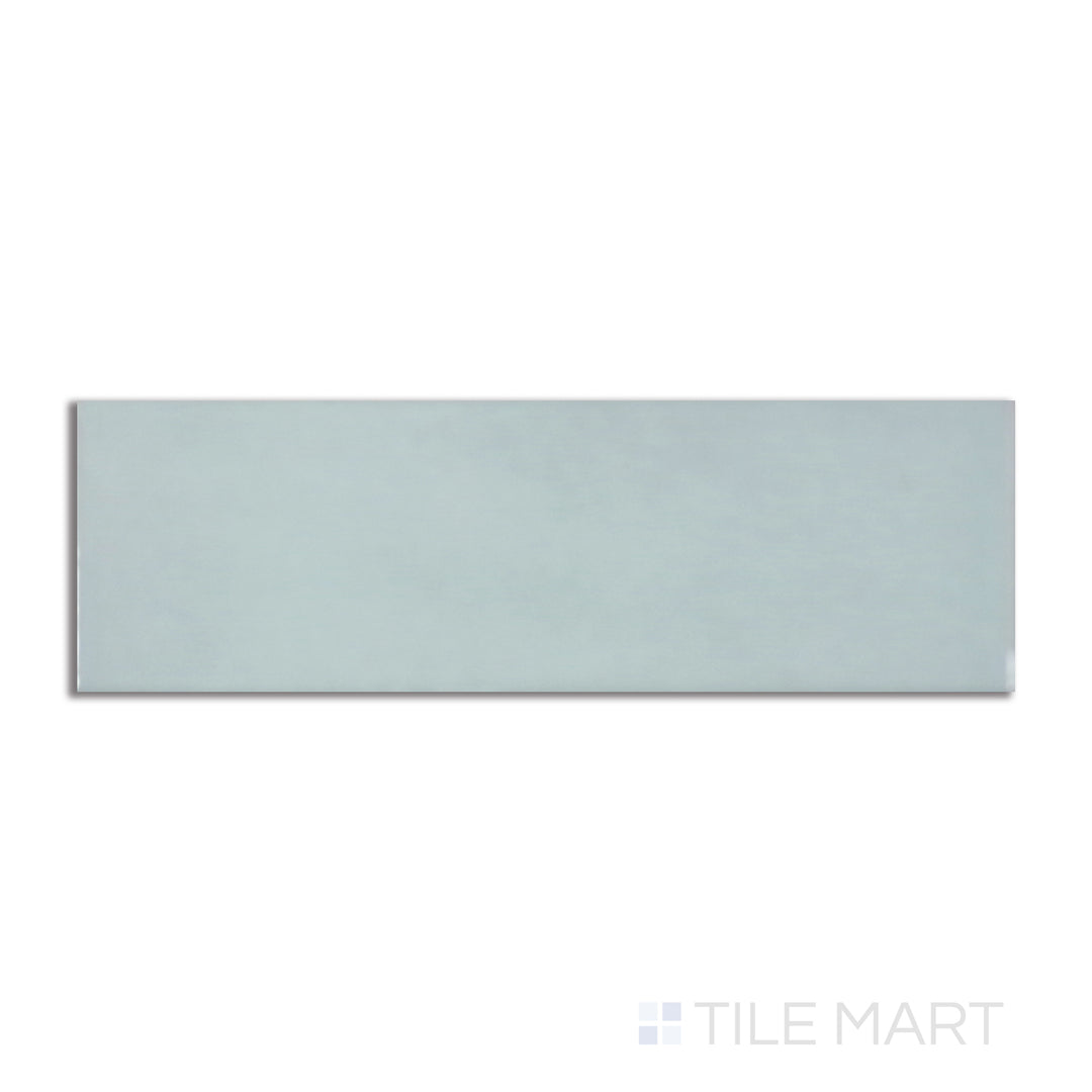 Flat-lay image of Village Mint 2.5X8 glossy ceramic tile, capturing a pastel green shade with a bright, reflective surface for a fresh aesthetic.
