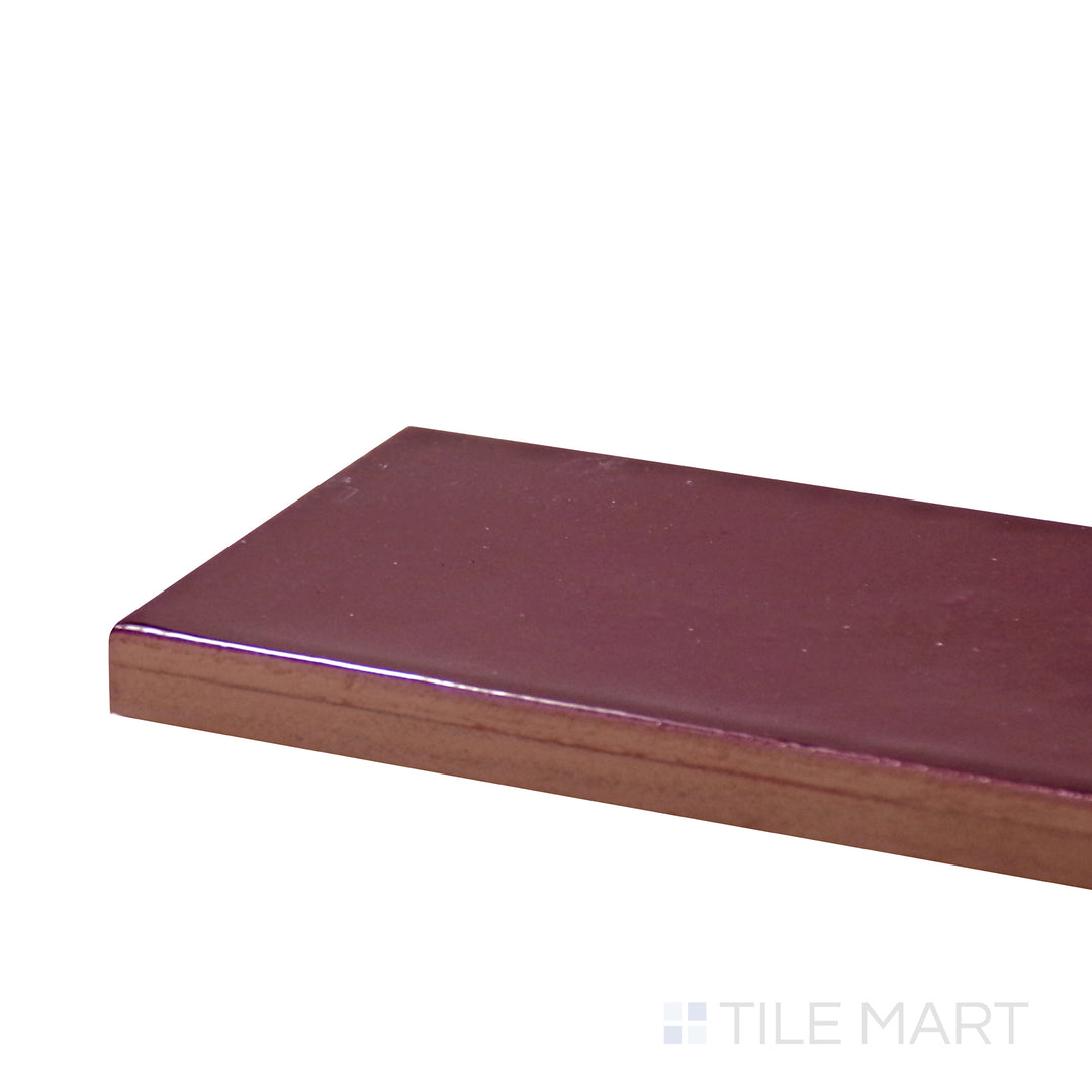 Side perspective of Village Aubergine 2.5X8 Glossy Ceramic Tile, capturing its deep purple hue with a smooth and glossy texture.