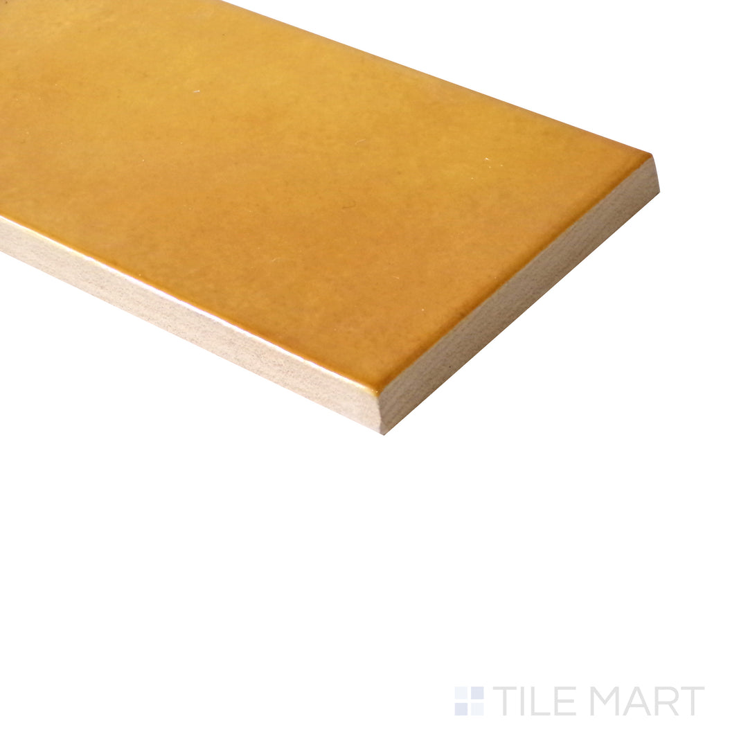 Angled shot of Village Tuscany Gold 2.5x8 glossy ceramic tile, featuring warm golden hues, sleek glossy finish, and an elongated rectangular shape.  